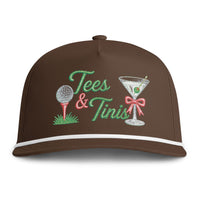 Load image into Gallery viewer, A brown baseball cap with embroidered 'Tees &amp; Tinis' text and golf-themed illustrations, including a golf ball on a tee and a martini glass with a pink bow, shown on a white background.