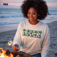 Load image into Gallery viewer, Beautiful Black woman with freckles and natural afro hair roasting marshmallows on the beach at dusk wearing an ivory Lucky faux patch long sleeve shirt