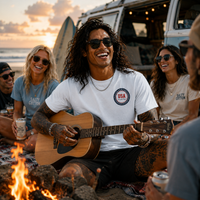 Load image into Gallery viewer, Man in patriotic shirt playing guitar with friends around a campfire on the beach at sunset.