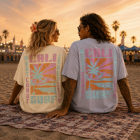 Load image into Gallery viewer, Two people sitting on a beach with 'California Surf' t-shirts on.