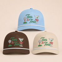 Load image into Gallery viewer, Three baseball caps arranged on a light beige background: a light blue cap at the top, a dark brown cap at the lower left, and a cream cap at the lower right. Each cap has embroidered green text reading 'Tees &amp; Tinis' with a golf ball, martini glass, red bow, and small grass accents.