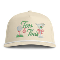 Load image into Gallery viewer, A rope embelished beige baseball cap with embroidered 'Tees &amp; Tinis' text, a golf ball on a tee, and a martini glass with a red bow on the front.