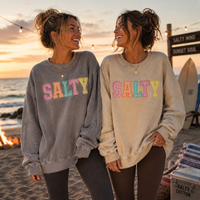 Load image into Gallery viewer, Two women wearing 'Salty' sweatshirts on a beach at sunset.