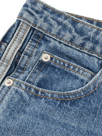 Load image into Gallery viewer, Close-up of a blue denim pair of jeans showing the back pocket, silver metal button, and contrast tan stitching.