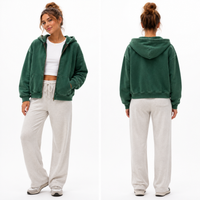 Load image into Gallery viewer, A brunette women in her 30's wears a dark green zip up hoodie that is vintage washed and oversized.
