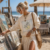Load image into Gallery viewer, Women in apricot sweatshirt and boho skirt is shopping in art gallery on the beach.